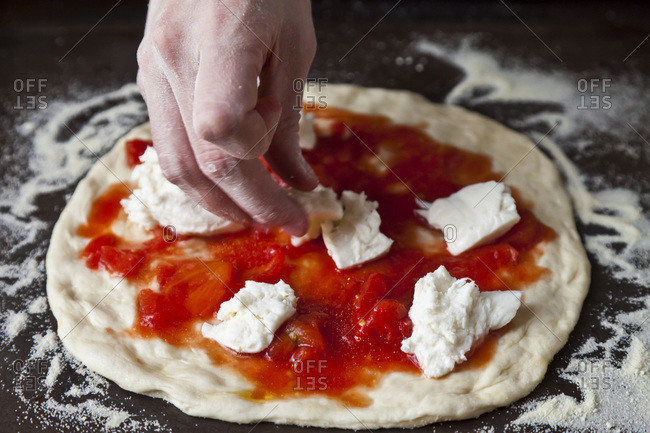 Sauce and mozzarella on pizza dough