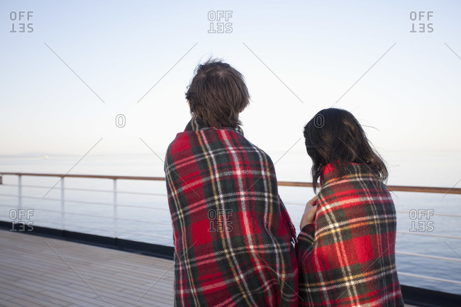 A couple on a ship deck, wrapped in blankets, looking at view, Seattle, Washington, USA