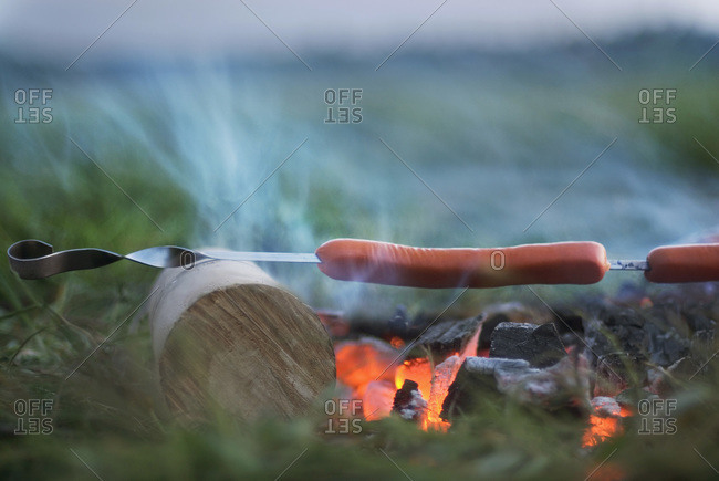 Sausages grilling over a fire