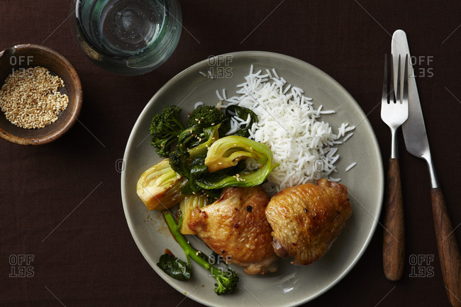 Roasted chicken legs with rice and broccoli as a side dish