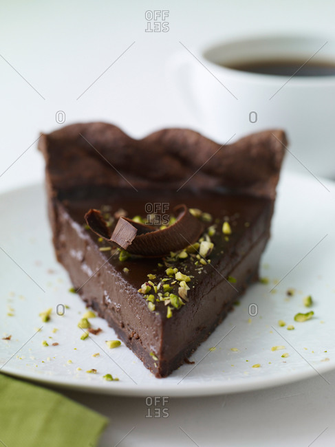 Triple chocolate tart with flake, whipped cream and pistachio on top.