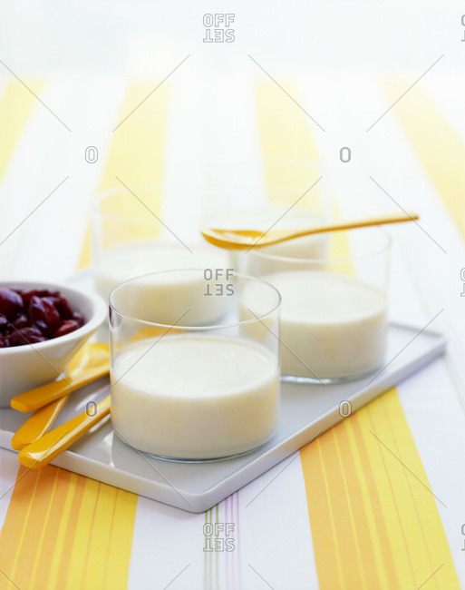 Milk pudding in a glass with cherry compote.