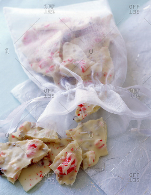 Homemade white chocolate bars with berries in a white sack.