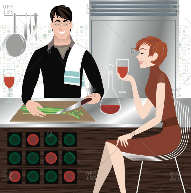 Man is making dinner while his girlfriend sits with him and drinks wine