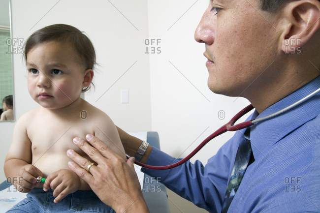 Doctor listening to young boy\'s heart