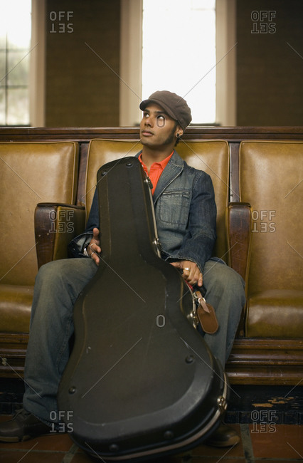Man sitting with guitar case