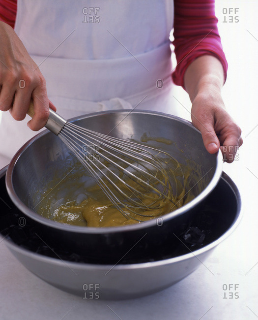 Close up of hands whisking pastry in a bowl