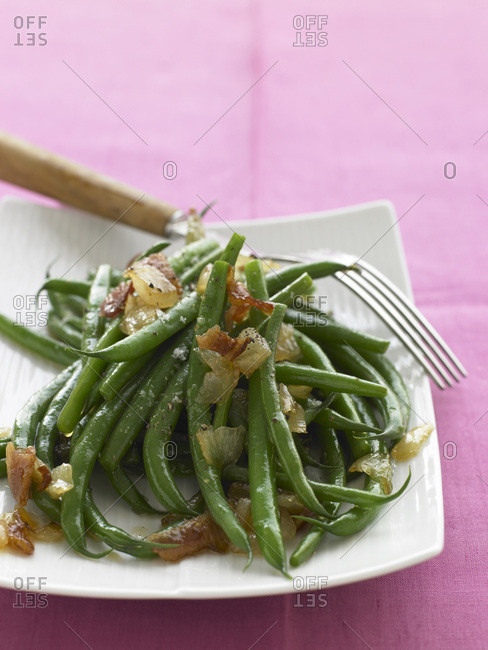 Stewed green bean on a white plate.