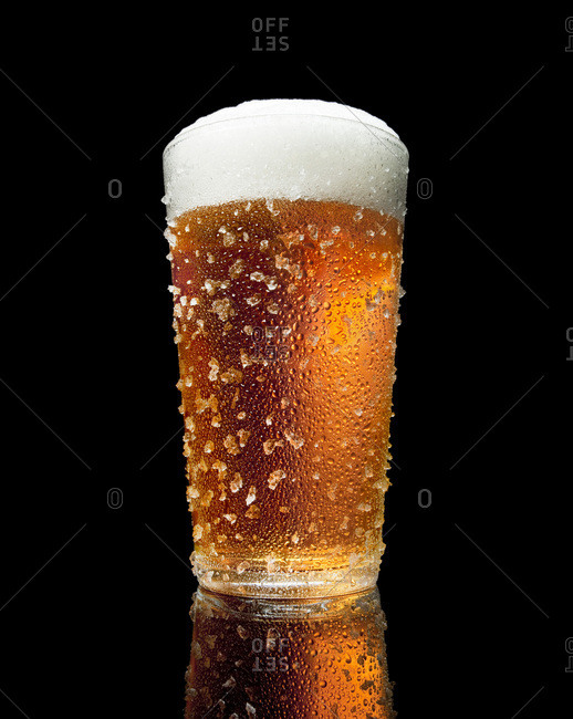 glass of beer with condensation and ice