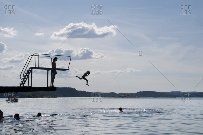 The silhouette of people bathing by a diving tower, Sweden