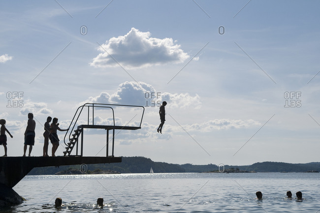 The silhouette of people bathing by a diving tower, Sweden