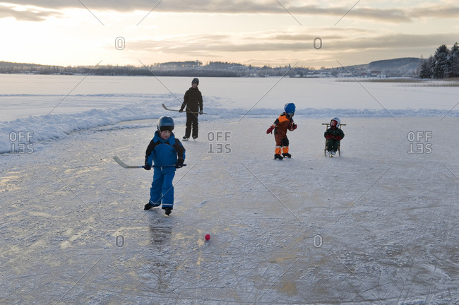 Children playing ice hockey on frozen Lake ball