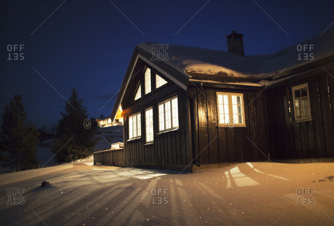 Wooden cabin in snow at night