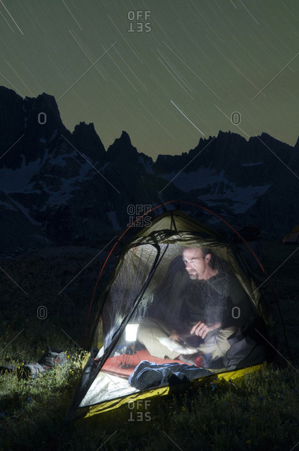 A male hiker in tent at night below the Cirque of Towers, Wind River Range, Pinedale, Wyoming.