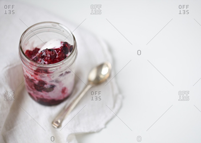 Vanilla ice cream with mixed berry sauce served in a jar