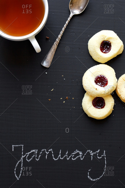 Tea, cookies and January word written on blackboard