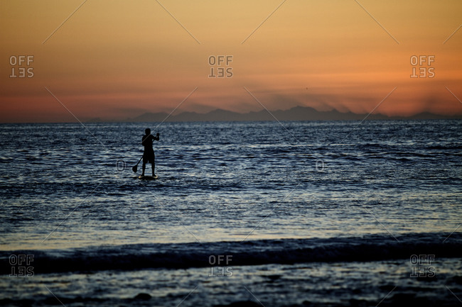 A male enjoying an evening stand up paddle board session with the last light of the day. Baja Mexico.(silhouette)