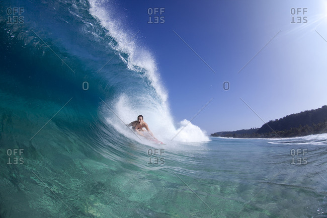 A water view of a surfer girl in the tube, in Hawaii