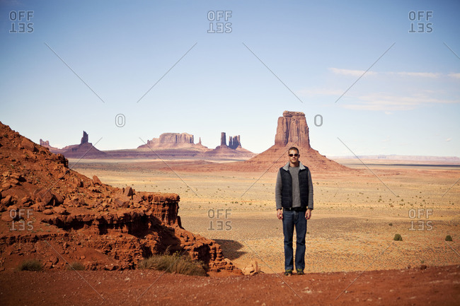 A man poses for a picture among the rock formations of Monument Valley on the Utah/Arizona border.