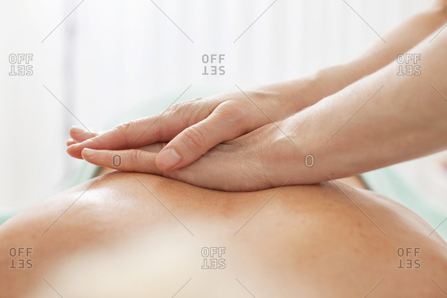 Close-up of human hand giving a back massage at beauty spa