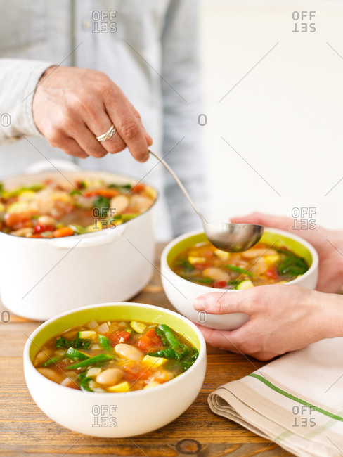 Serving bean soup into bowls