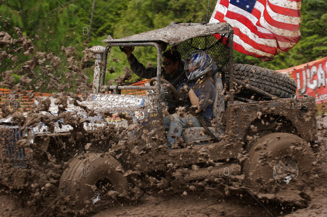 Drivers compete on a mud bog course with all-terrain vehicles