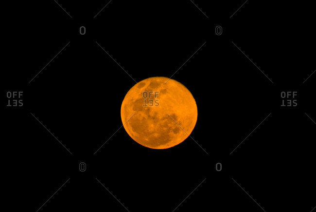 A full moon colored red by atmospheric dust is known as a blood moon