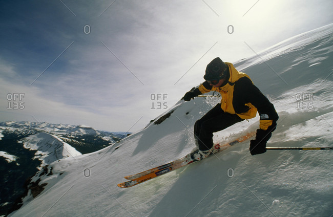 An extreme skier races down a sheer slope