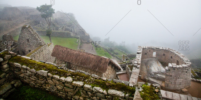 The Temple of the Sun with morning fog at Machu Picchu, Peru