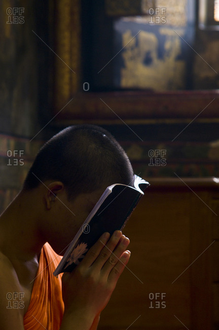 A Buddhist monk in deep prayer in the Ubosot, the temple's chapel.