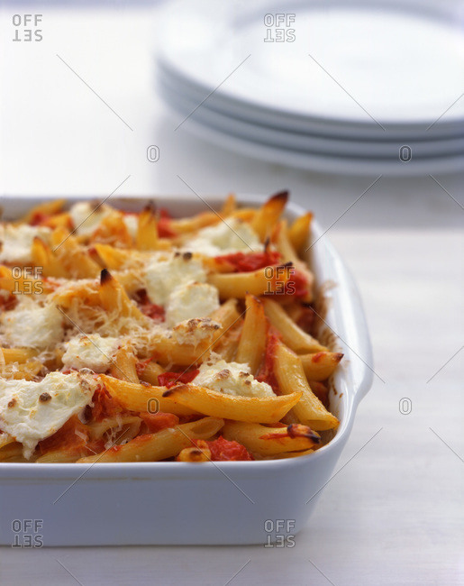 Baked ziti pasta with tomato chunks and melted cheese for a family dinner