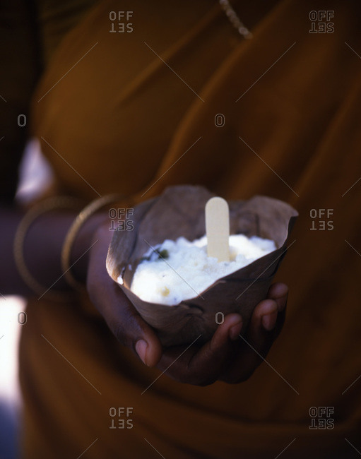 Indian woman holding curd rice in natural bowl