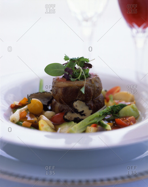 Oven baked meat roulade served in deep plate with vegetables