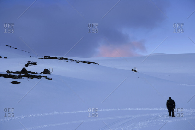 Man Walking Through The Mountain Snow