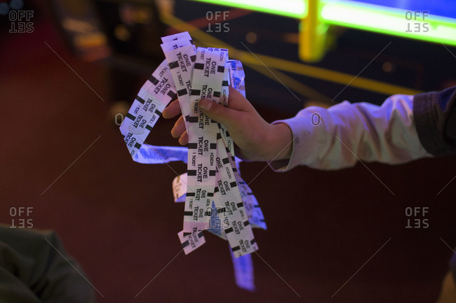 a child holds arcade game tickets