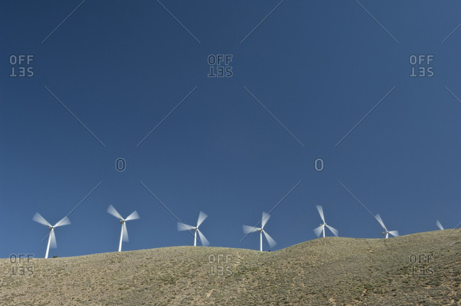 Wind turbines in movement against blue sky
