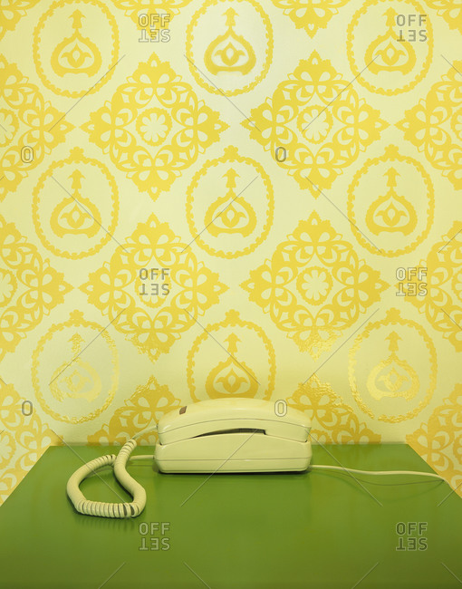 Vintage interior with a yellow wallpaper and a telephone