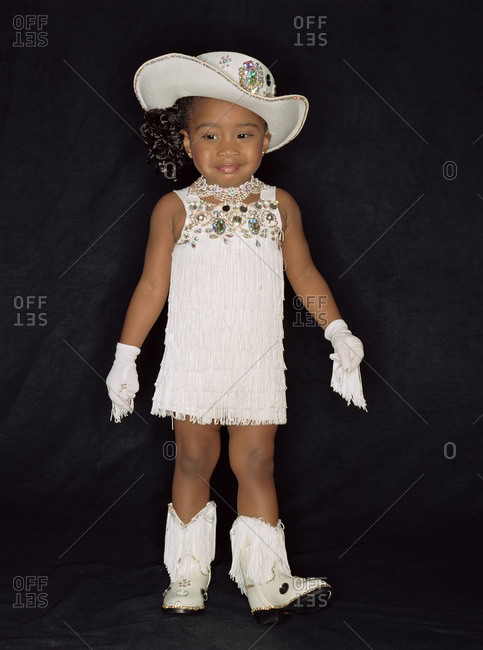 Child Beauty Queen Wearing Jewel Studded Hat And Fringed Gloves With Boots And Dress