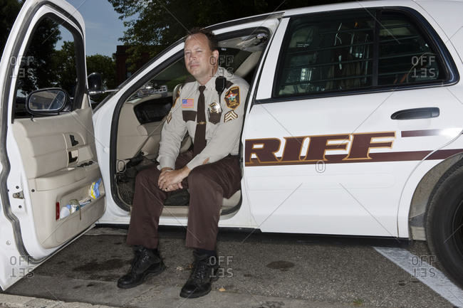 A Rice County Police Officer Poses For A Portrait In His Patrol Car
