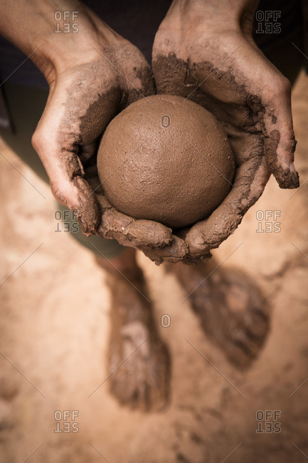 Close up of hand holding wet mud ball