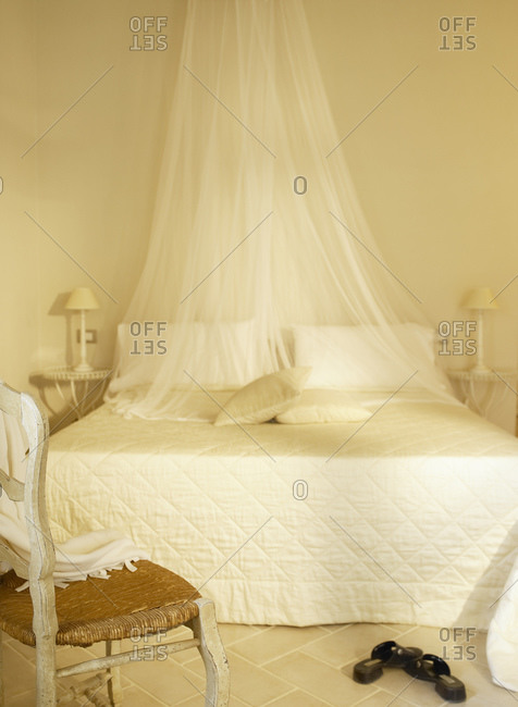 A white hotel room with mosquito net