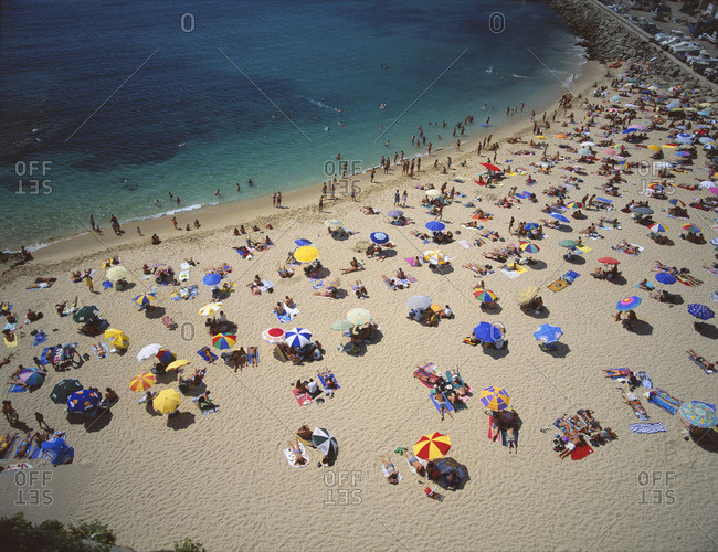 Aerial view of crowded beach with sunshades