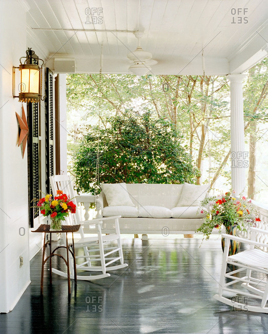 White porch with rocking chairs and swing porch bed