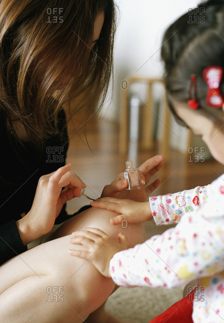mother painting daughter\'s fingernails