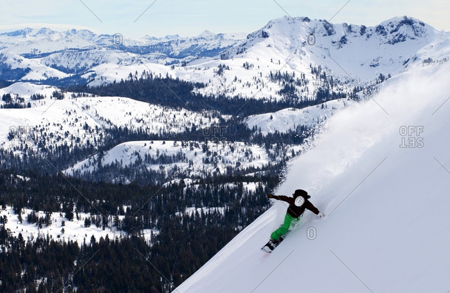 A snowboarder rips a huge turn in deep powder on Red Lake Peak off of Carson Pass near Lake Tahoe, CA.
