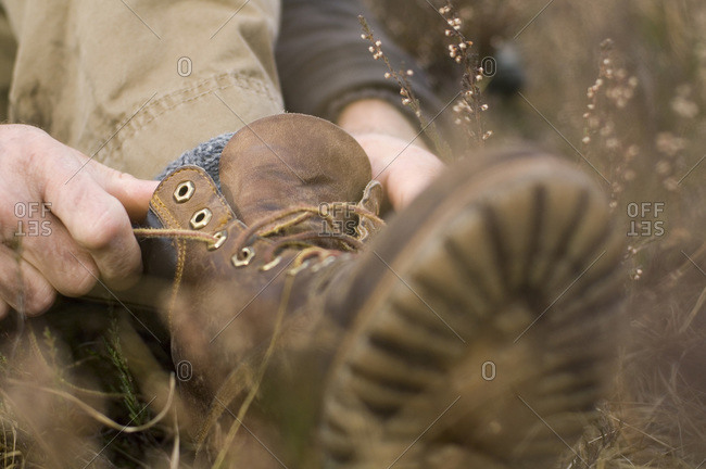 Close up of a man lacing his hiking boots