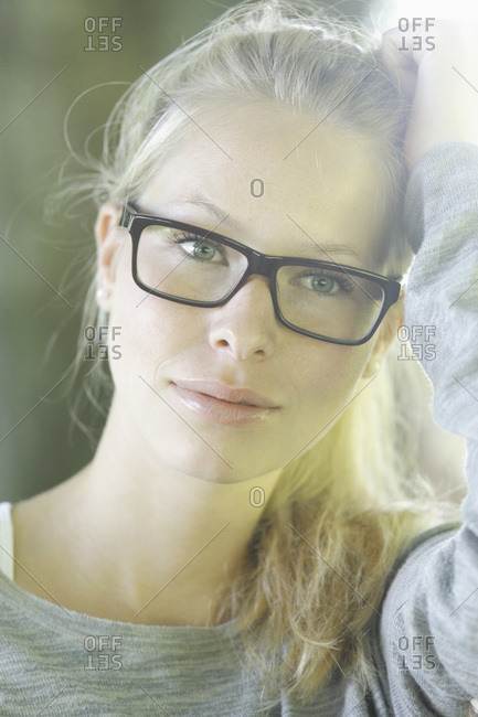 Germany, Bavaria, Schaeftlarn, Young woman wearing thick rimmed spectacles, smiling, close up