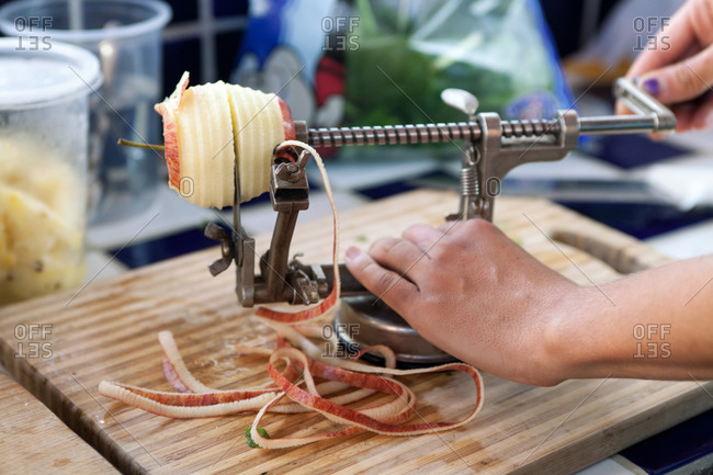 Close up of hands peeling apple with an apple peeling machine