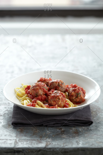 Spaghetti and meatball dinner served on white plate