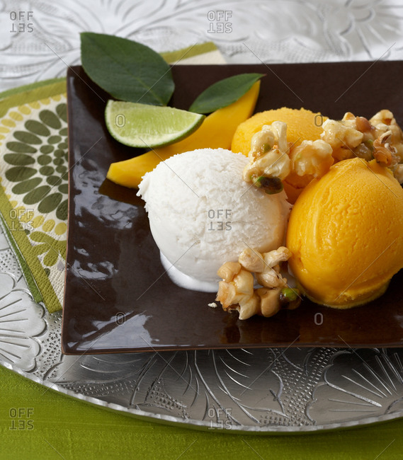 Coconut and mango sorbet garnish with fresh lime and mango wedges